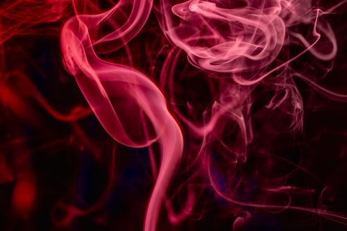 Free Vibrant abstract image of swirling pink and red smoke on a dark background, creating an ethereal and artistic atmosphere. Stock Photo