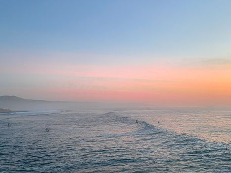 A tranquil scene of ocean waves during a vibrant sunset, creating a serene atmosphere.