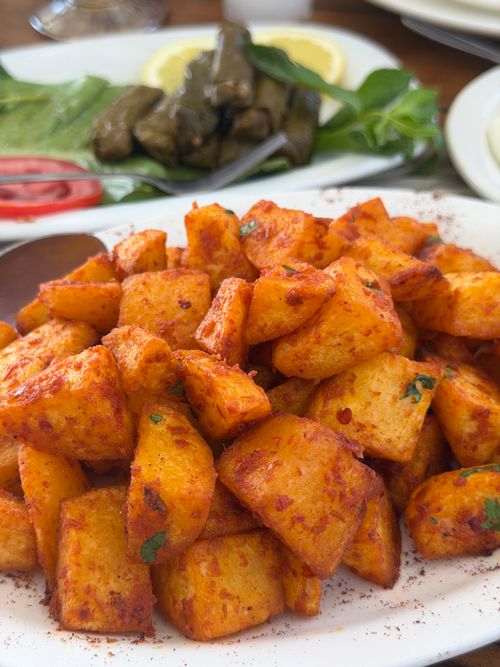 Free Close-up of spicy roasted potatoes served with Mediterranean side dishes, perfect for a flavorful meal. Stock Photo