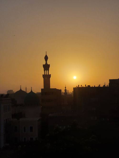 Free Beautiful silhouette of mosque minarets against a warm sunset sky in Cairo, Egypt. Stock Photo