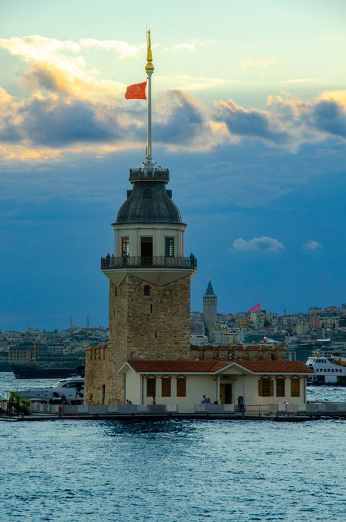 Free Majestic view of Istanbul's Maiden's Tower with skyline and Galata Tower in the background at sunset. Stock Photo
