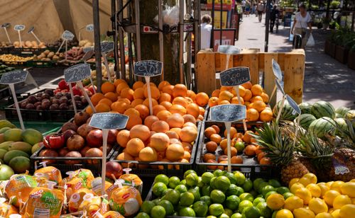 Free Vibrant outdoor market scene showcasing citrus fruits, pineapples, and other tropical produce. Stock Photo