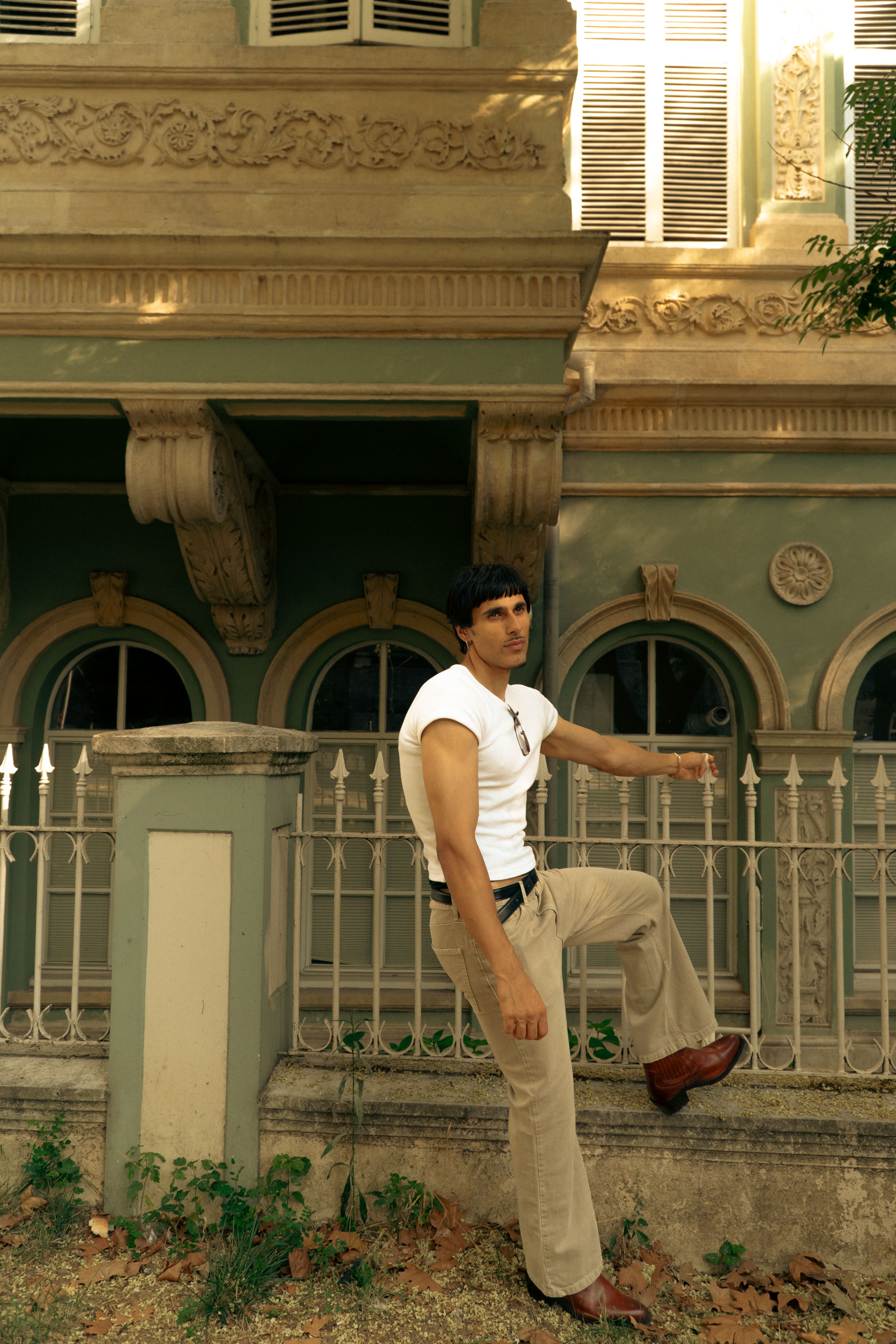 Man in casual attire posing next to a historic building in Istanbul, showcasing urban style and elegance.