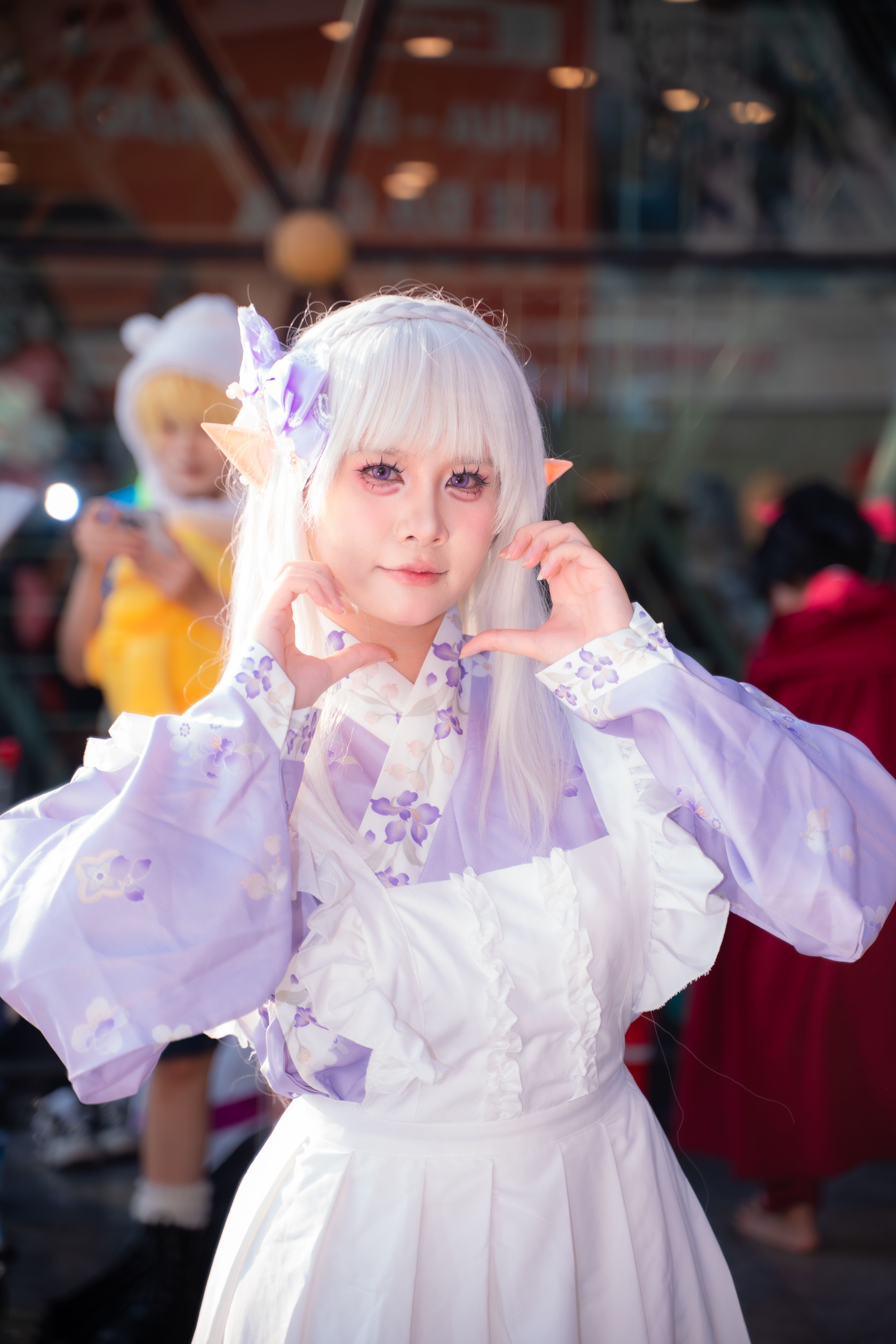Anime cosplay enthusiast in a whimsical lavender outfit posing joyfully.