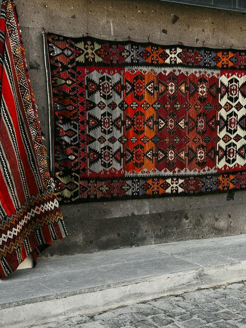 Free Intricate traditional Middle Eastern rugs with geometric patterns on display outdoors. Stock Photo