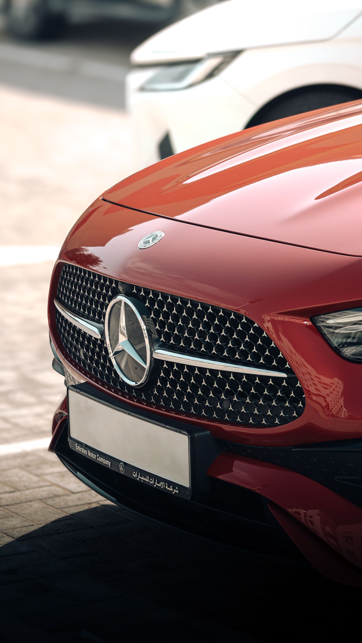Close-up of a sleek red Mercedes-Benz parked outdoors in the UAE, showcasing elegance and luxury.
