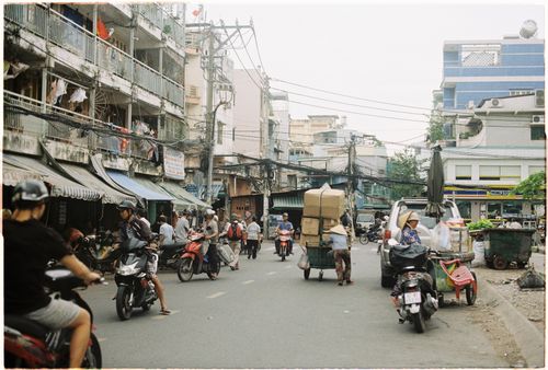 Free A busy Asian street market with scooters and pedestrians during the day. Stock Photo