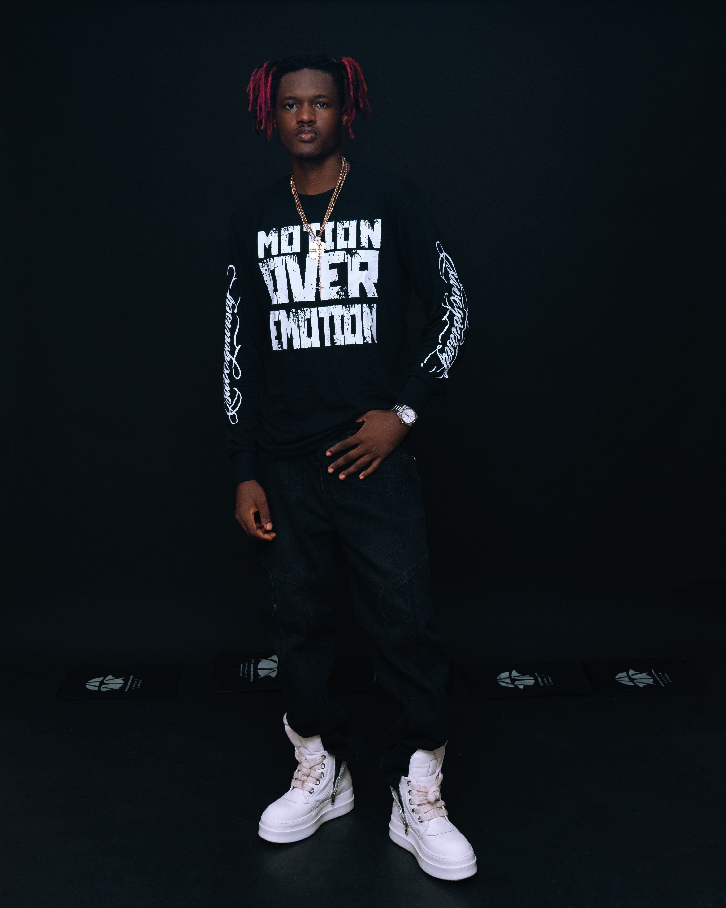Stylish young man in urban streetwear poses in a studio setting.