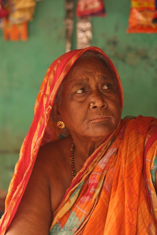 Free Portrait of an elderly woman in vibrant traditional clothing with a thoughtful gaze. Stock Photo