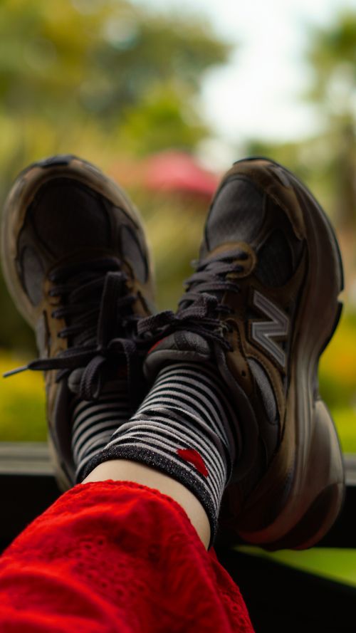 Free Person relaxing with sneakers against a scenic outdoor backdrop, capturing leisure. Stock Photo