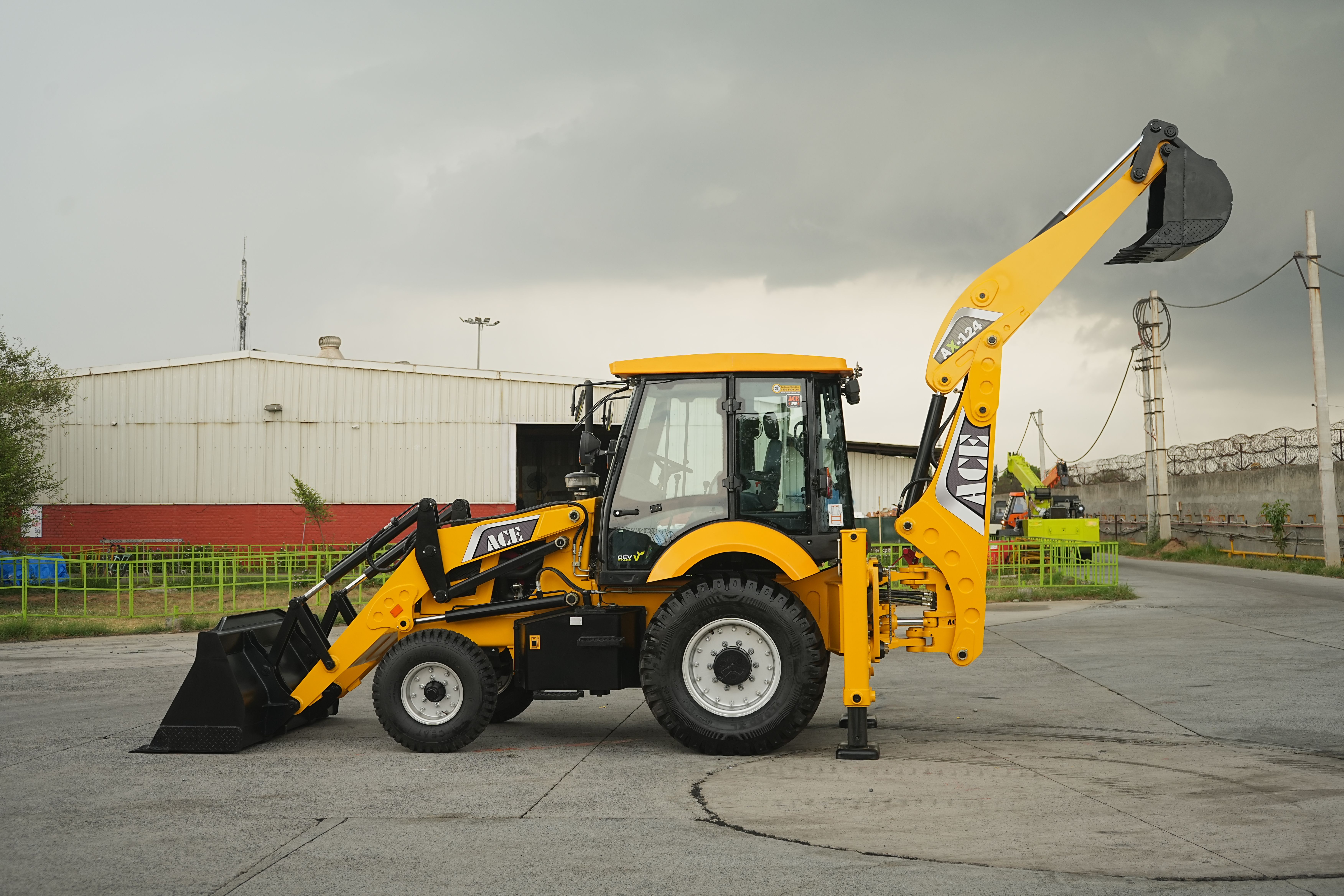 Side view of an ACE backhoe loader at a construction site in Faridabad, India.