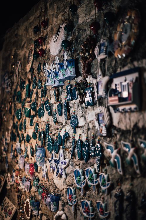 Free A collection of colorful ceramic souvenirs displayed on a rustic stone wall, perfect for travel and culture themes. Stock Photo