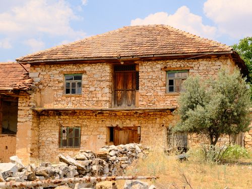 Free Charming old stone house with weathered wooden doors in a rural area of Uşak, Türkiye. Stock Photo