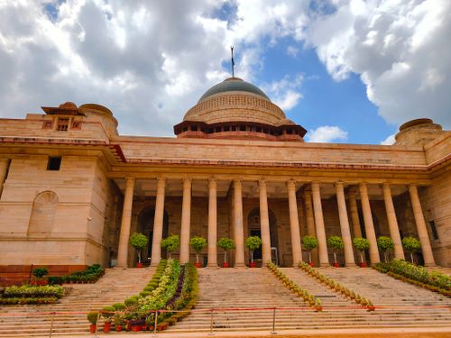 Free Rashtrapati Bhavan with its domed architecture under a partly cloudy sky in Delhi, India. Stock Photo