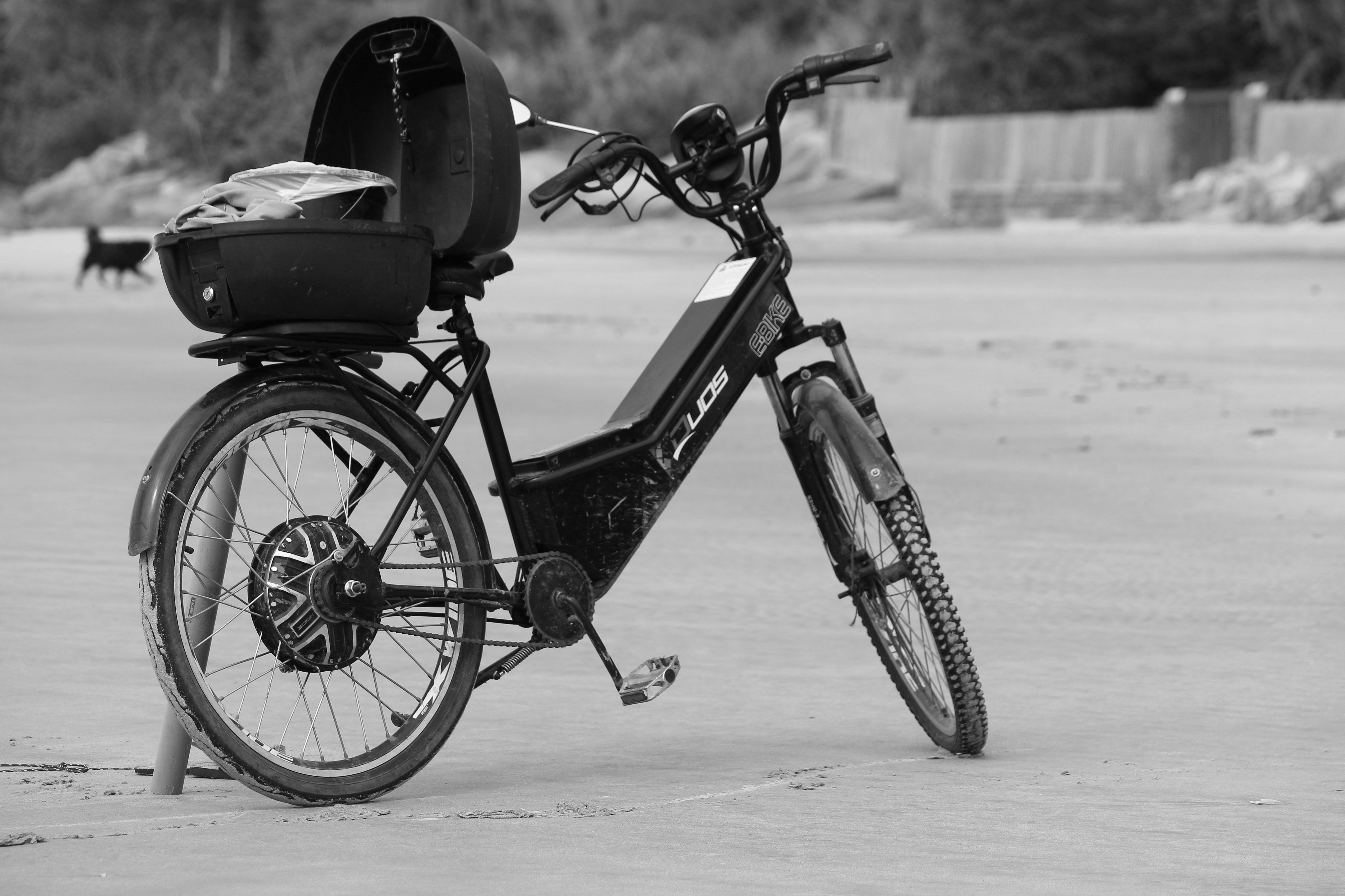 Black and white photo of an electric bike parked on Guaratuba Beach.