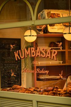 A cozy artisan bakery displaying a variety of fresh bread loaves through a window.