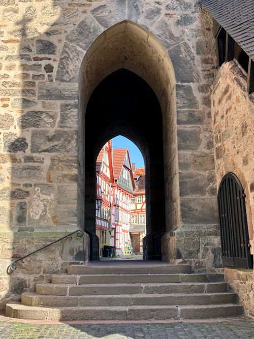 Free Beautiful view through a medieval archway revealing Idstein's charming half-timbered houses. Stock Photo
