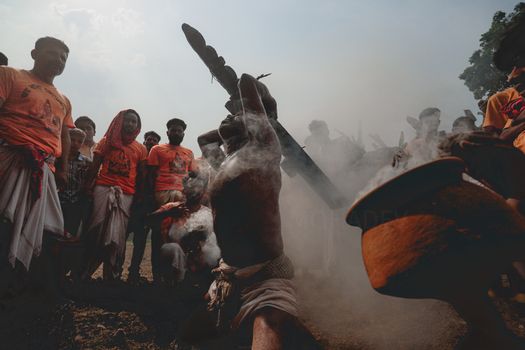 A spiritual ritual with smoke during a traditional ceremony surrounded by people.
