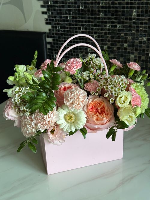 Free Beautiful floral arrangement in a pink bag with mixed blooms for a fresh, elegant look. Stock Photo