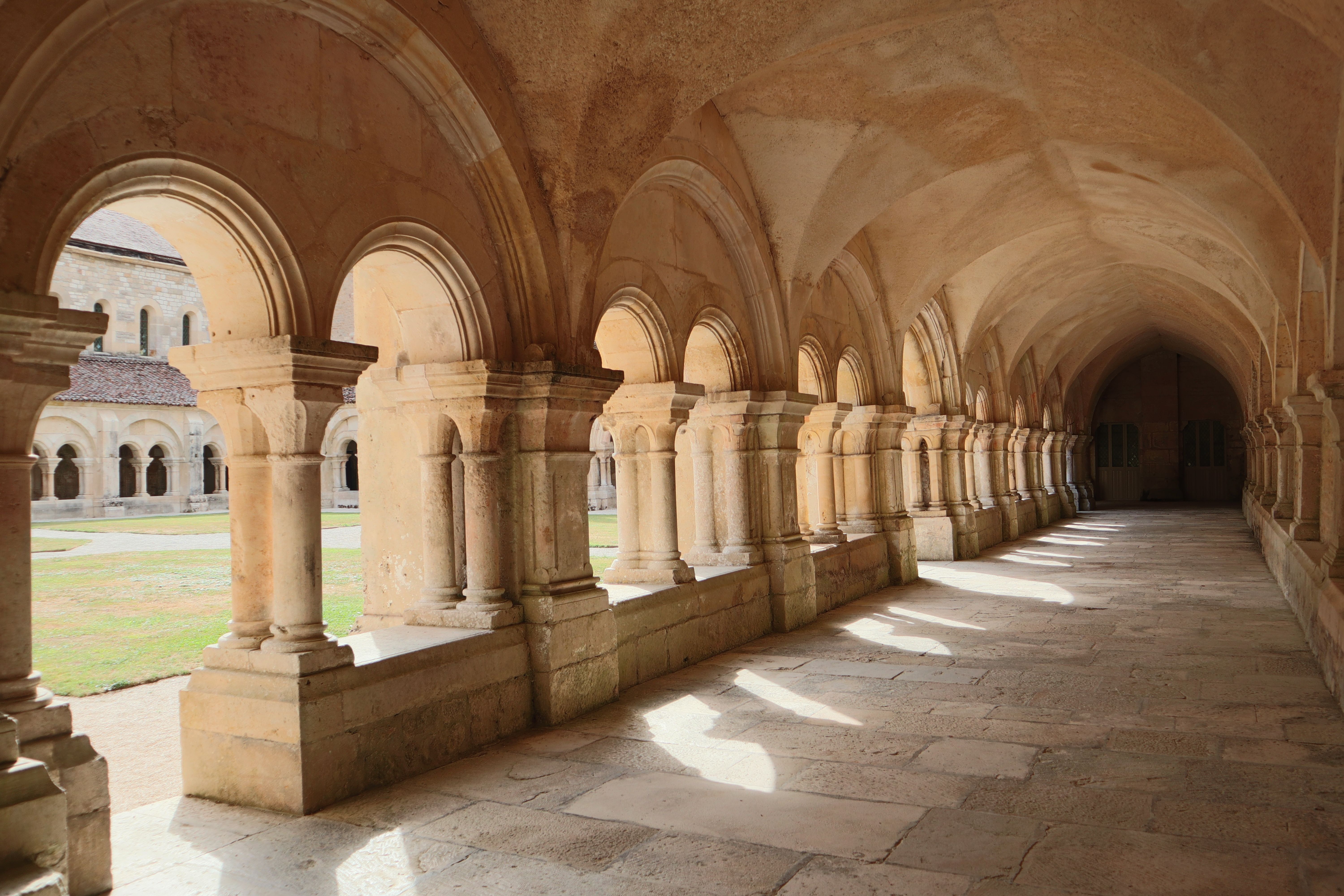 Beautiful stone arches of a historic cloister in Montbard, exemplifying Romanesque architecture.