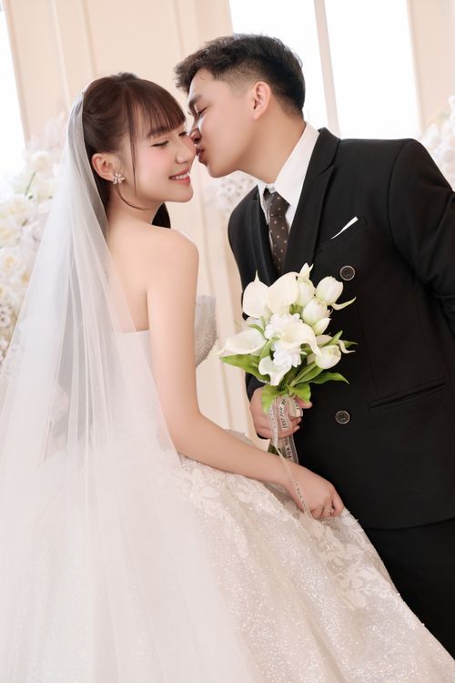 Free Bridal couple sharing a tender kiss with elegance and charm on their wedding day. Stock Photo