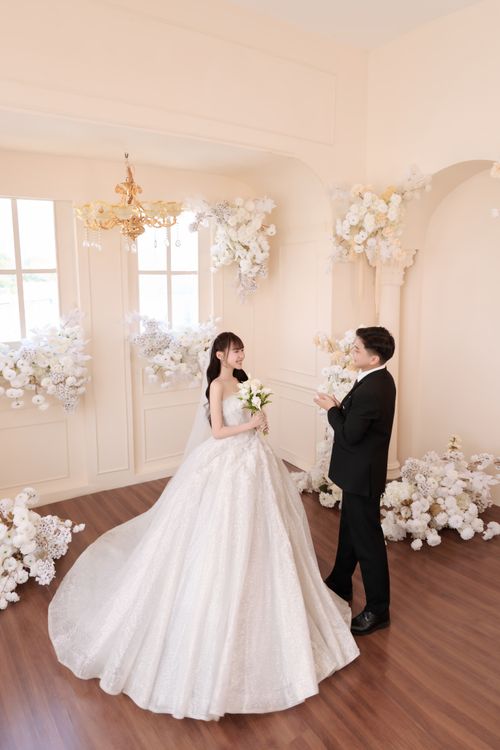 Free Beautiful indoor wedding portrait of a couple in a luxurious setting with floral decorations. Stock Photo