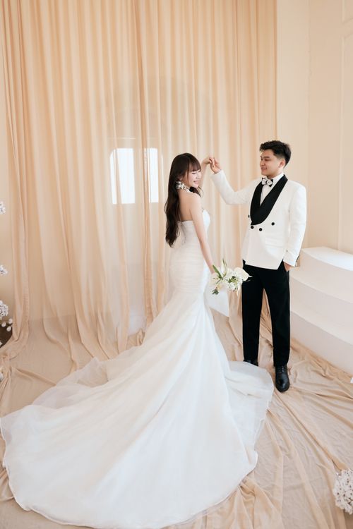 Free Bride and groom dancing indoors in elegant attire, captured in a graceful moment. Stock Photo