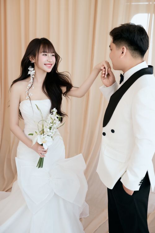 Free Elegant indoor wedding portrait with bride in white gown and groom in tuxedo. Stock Photo