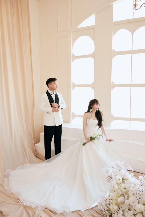 Free A sophisticated bride and groom in formal attire inside a bright, elegant venue. Stock Photo