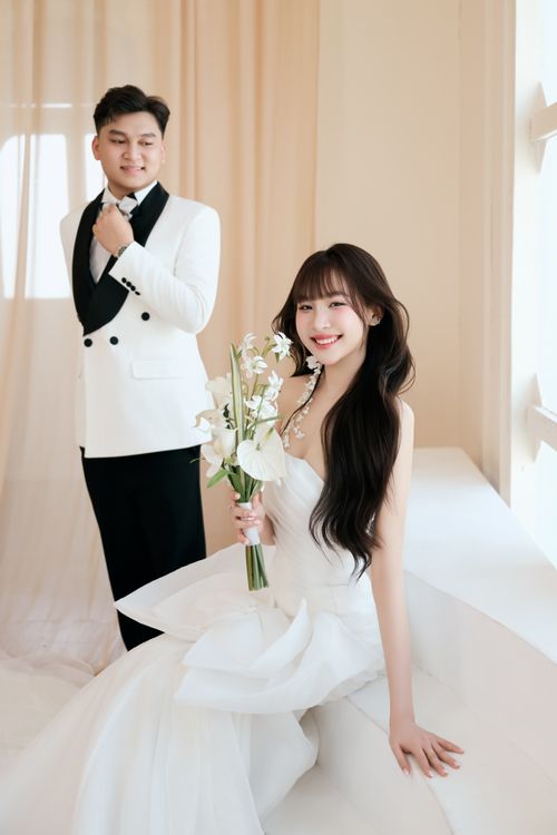 Free A joyful couple in elegant wedding attire posing indoors with soft natural light. Stock Photo
