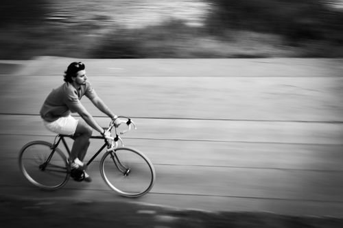 Free Dynamic black and white image of a cyclist in motion on a city pathway. Stock Photo