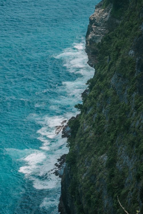 Free A breathtaking aerial view of rugged cliffs and vibrant turquoise waters in Indonesia. Perfect for travel inspiration. Stock Photo