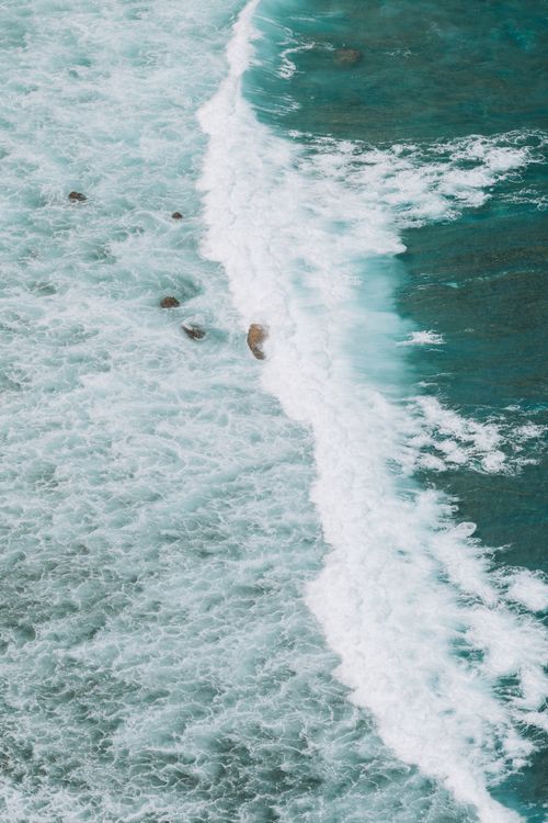 Free Captivating aerial shot of waves crashing along the Indonesian coastline, showcasing beauty of nature. Stock Photo