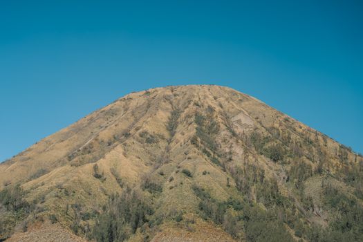 Breathtaking view of Mount Bromo set against a clear blue sky, capturing its unique landscape.