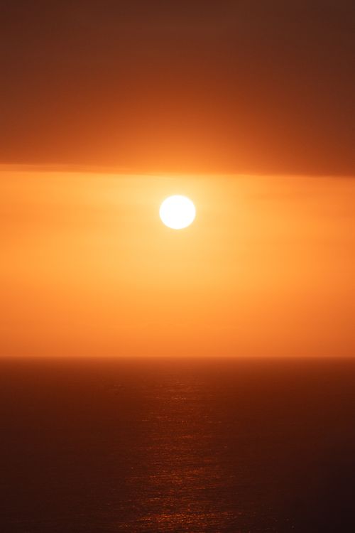 Free A breathtaking sunset over the ocean in Indonesia, creating a warm and tranquil scene. Stock Photo