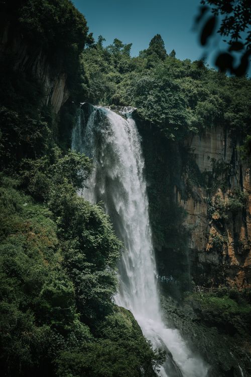 Free A breathtaking waterfall cascades through lush greenery in Guizhou, China, captured in vivid detail. Stock Photo