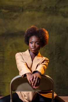 Elegant portrait of a woman seated, wearing a beige blazer.