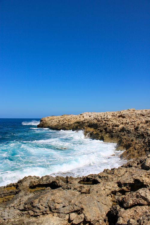 Free A stunning view of the rocky coastline against the vibrant blue sea in Pigadia, Greece. Stock Photo