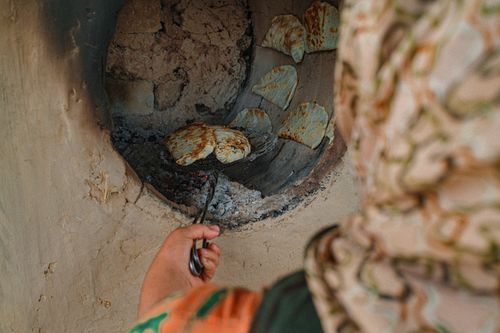 Free A person baking bread in a clay oven in Tashkent, Uzbekistan. Stock Photo
