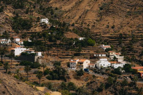 Free Explore the picturesque terraced landscape of Taguluche, Spain with its charming hillside village and lush palm trees. Stock Photo