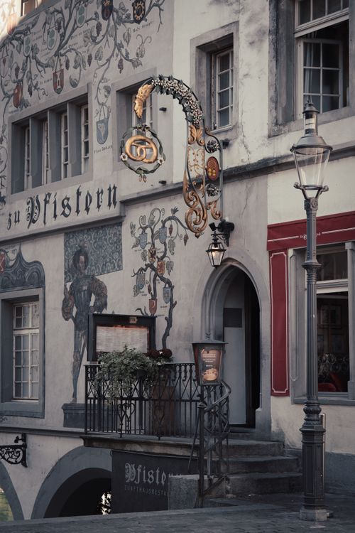 Free Charming historical building facade with intricate signage and artistic details in warm tones. Stock Photo
