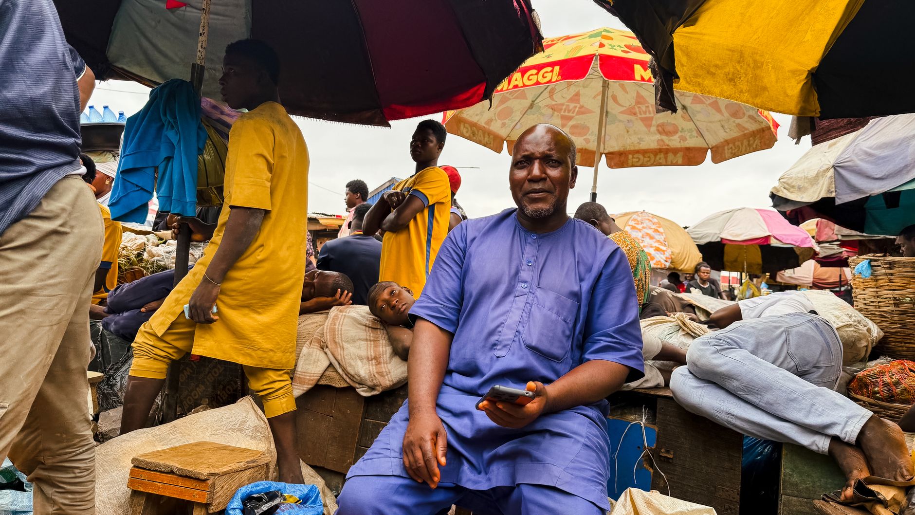 Vendors and small traders at a bustling outdoor market in Nigeria.