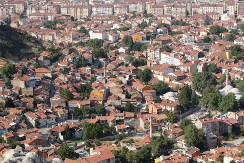 Free Explore the sprawling cityscape with red rooftops and lush greenery from an aerial perspective. Stock Photo