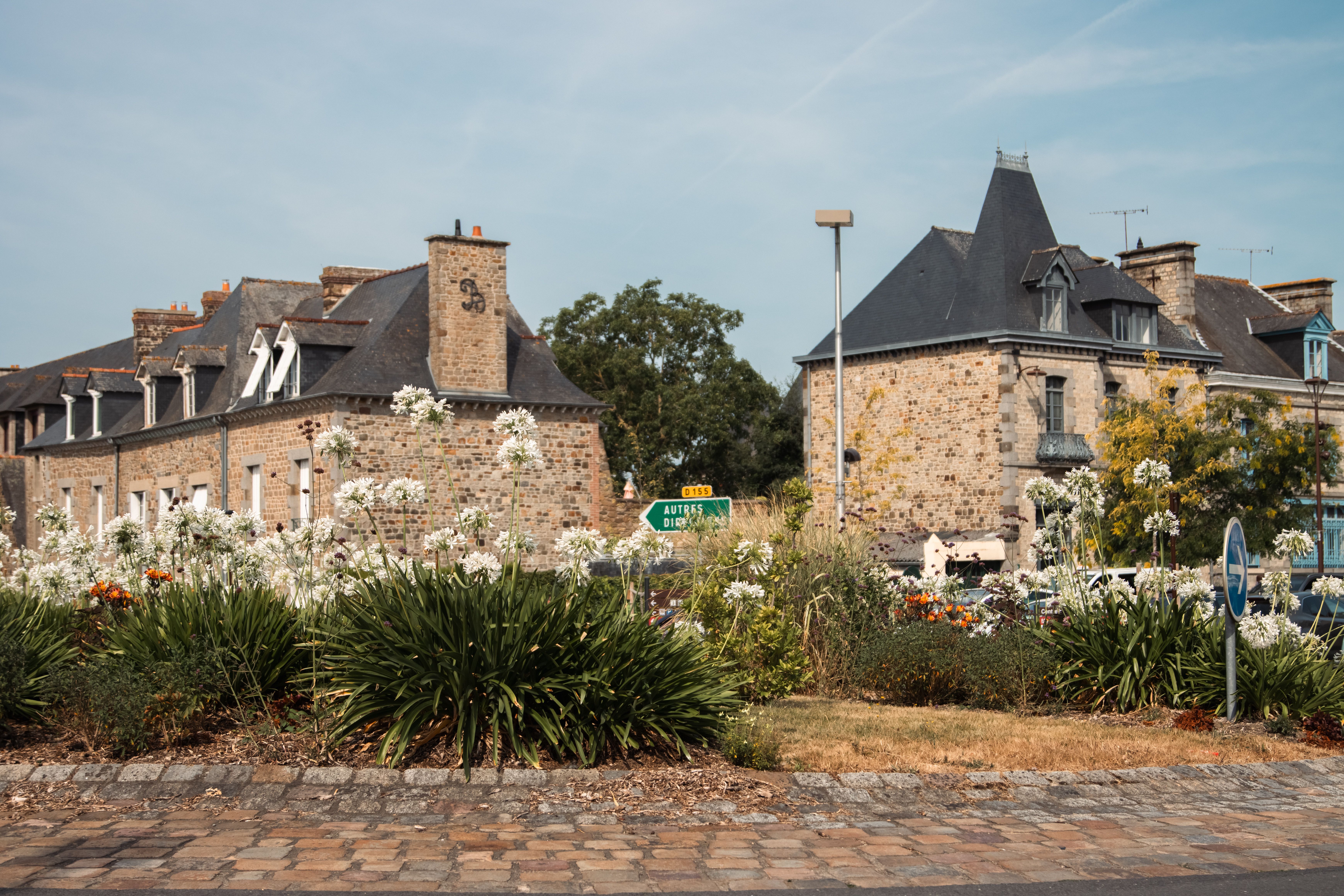 Picturesque view of historic stone buildings surrounded by flowers in Dol-de-Bretagne, France.