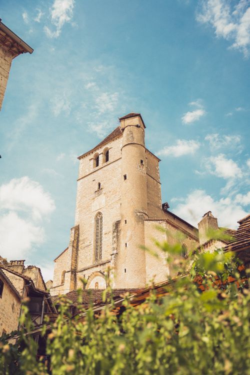 Free Beautiful historic church tower against a blue sky in Saint-Cirq-Lapopie, France. Stock Photo