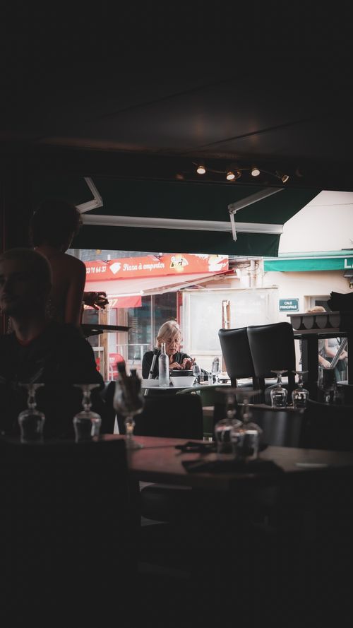 Free A moody indoor cafe scene capturing diners in a cozy setting in Normandy. Stock Photo