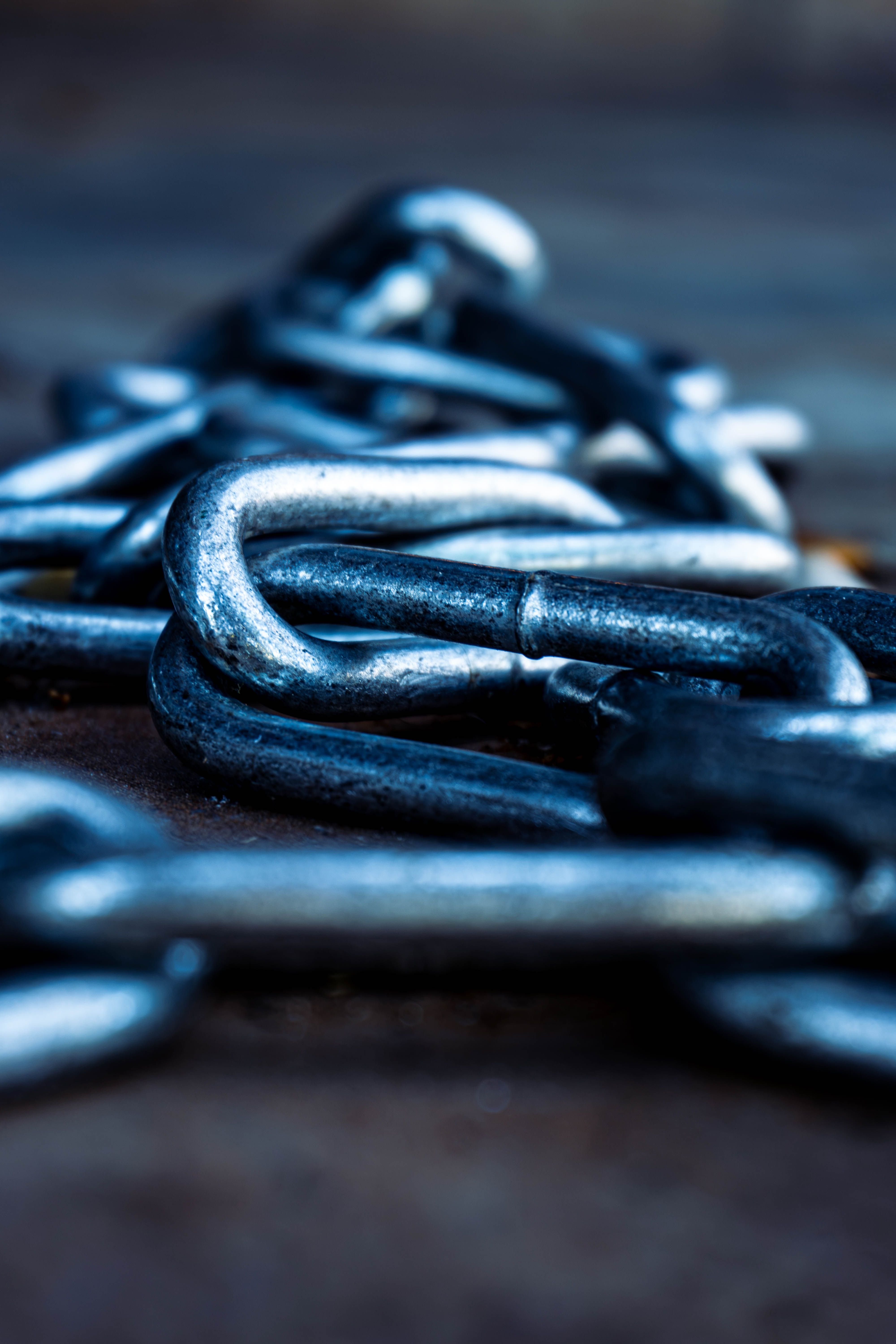 Artistic close-up of metal chain links in focus with blurred background.
