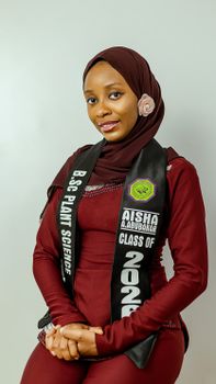 Portrait of a female plant science graduate with a graduation sash and hijab, class of 2022.