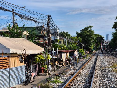 Free A vibrant street market scene alongside railway tracks in Bangkok, Thailand. Stock Photo