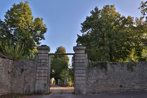 Free Majestic stone gateway framed by lush green trees in Montbard, France Stock Photo